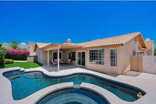 a house with a swimming pool in front of a house at Spacious house with pool at Mission Lake in Desert Hot Springs