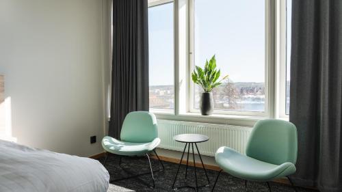 una habitación de hotel con 2 sillas y una ventana en Comfort Hotel Skellefteå, en Skellefteå