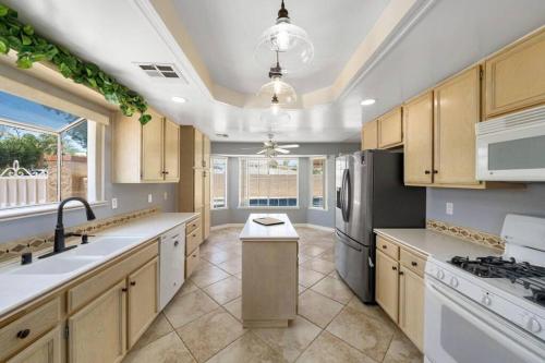 a kitchen with a sink and a refrigerator at Spacious house with pool at Mission Lake in Desert Hot Springs