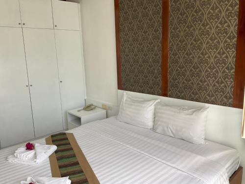 a bedroom with a bed with white sheets and white pillows at The Sand Beach Pattaya in Na Jomtien