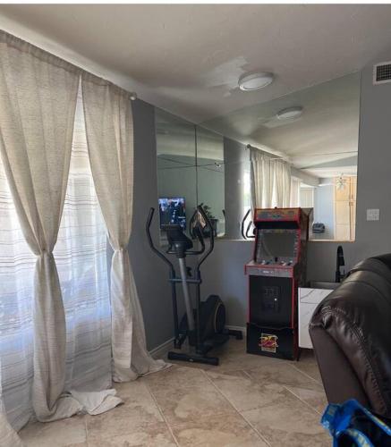 a living room with a treadmill and a window at Spacious house with pool at Mission Lake in Desert Hot Springs