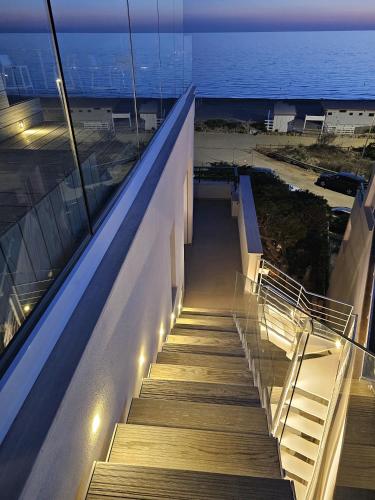 a staircase leading down to the ocean at night at Villa Dune Luxury Roof Top Pool Wellness in Gallipoli