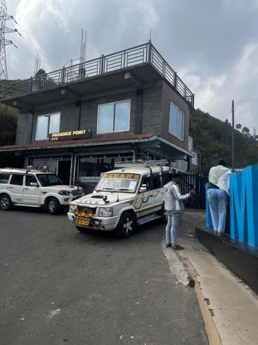 un groupe de personnes debout devant un immeuble avec un bus dans l'établissement Paradise Point Hotel & Restro, à Darjeeling