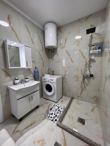 a bathroom with a sink and a washing machine at R&D Central Apartment in Prilep