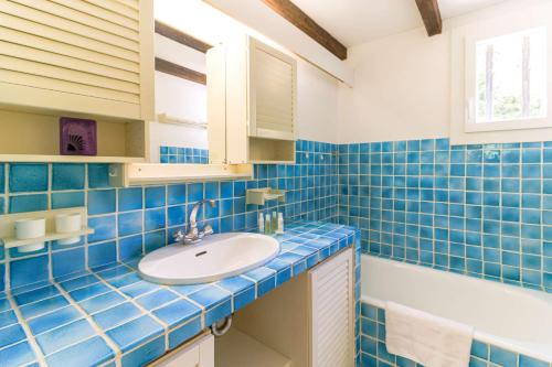 a blue tiled bathroom with a sink and a tub at SELECT'SO HOME - Mas des Canadels - Services hôteliers & Prestations de qualité - RCMAS in Rayol-Canadel-sur-Mer