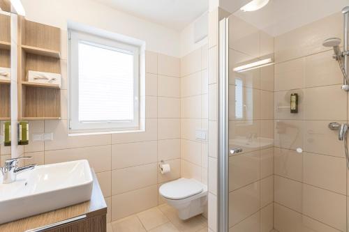 a bathroom with a toilet and a sink and a shower at Almresort Gartnerkofel Nassfeld in Sonnenalpe Nassfeld
