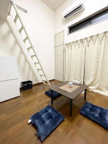 福岡市にあるGest Residence Hakata Tenjin self check inのリビングルーム(テーブル、階段付)