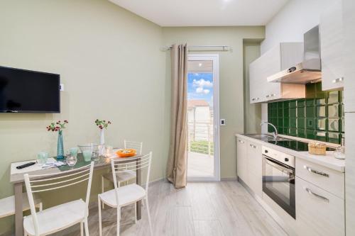 a kitchen with a table and chairs and a counter at Eclisse House Few Steps From The Sea - Happy Rentals in Augusta