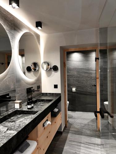a bathroom with two sinks and a shower at LARET private Boutique Hotel - Adults only in Samnaun