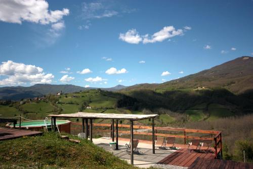 a deck with chairs and a view of the mountains at Società Agricola Cacigolara in Borgo Val di Taro
