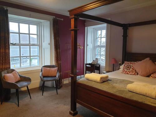 a bedroom with a canopy bed and a chair at Lime Tree Hotel in Fort William