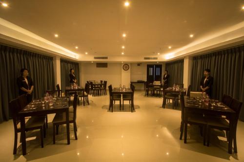 a dining room with tables with people standing in the background at TANTRA BOUTIQUE HOTEL in Imphal