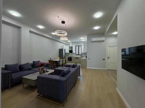 uma sala de estar com sofás azuis e uma cozinha em GS Premium em Yerevan
