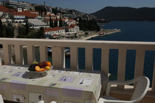 a table with a bowl of fruit on top of a balcony at Villa Lasić Neum in Neum
