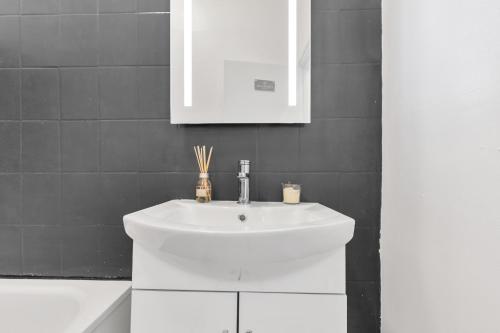 a bathroom with a white sink and a mirror at The Brixton Inn in London