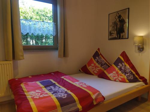 a bed in a room with a window and pillows at Schlafende Hexe in Bischofswiesen