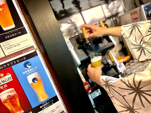 a person making a drink in a drink vending machine at Hanasuishou in Fuefuki