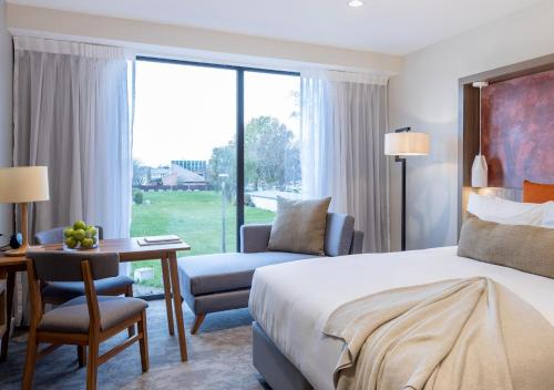 Sudima Christchurch City في كرايستشيرش: غرفه فندقيه بسرير ومكتب وكرسي