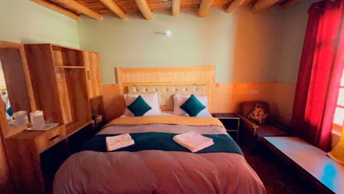 ein Schlafzimmer mit einem großen Bett mit zwei Kissen in der Unterkunft Hotel Pangong Residency in Leh
