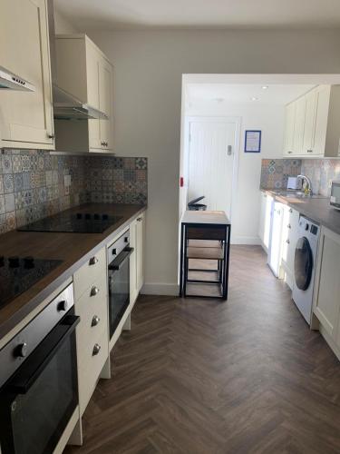 a kitchen with white cabinets and a table in it at Cleadon in Goole