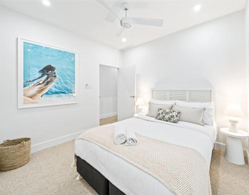 a bedroom with a king sized bed and a picture of a bird at Peach at Palm View Collective in Sydney