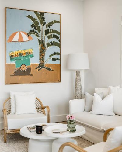 a living room with a couch and a table at Peach at Palm View Collective in Sydney