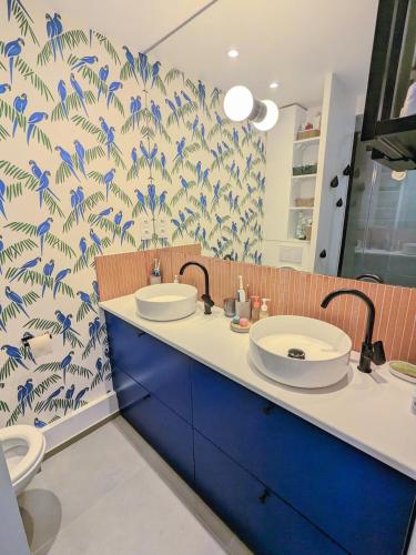 baño con 2 lavabos y papel pintado azul y blanco en Maison paisible Jardin & Jacuzzi à 500m de Paris, en Pantin