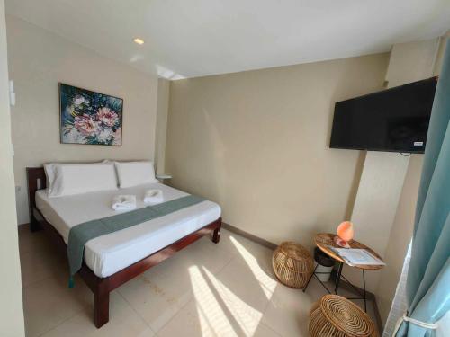 1 dormitorio con 1 cama y TV de pantalla plana en PrimeRose Residences, en Lapu Lapu City