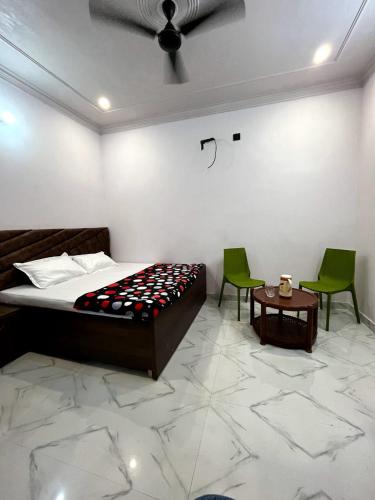 1 dormitorio con 1 cama, 2 sillas y mesa en Vinayak home stay, en Mathura