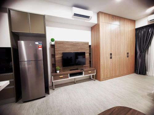 a living room with a refrigerator and a television at Bell Suite 4pax Sepang Kota Warisan KLIA in Sepang