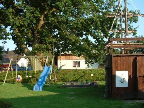 a playground with a blue slide in a yard at Haus Jasmin in Bodstedt