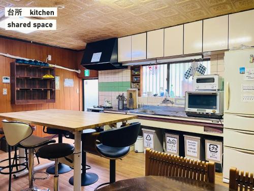 uma cozinha com uma mesa de madeira e algumas cadeiras em TAKIO Guesthouse - Vacation STAY 11600v em Higashi-osaka