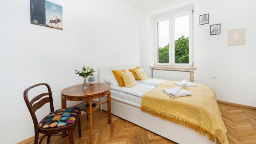 um quarto com uma cama, uma mesa e uma janela em Apartamenty Sun & Snow Basztowa na Cracóvia