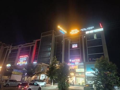 un edificio con coches aparcados delante de él por la noche en hotel shivkunj, en Ahmedabad