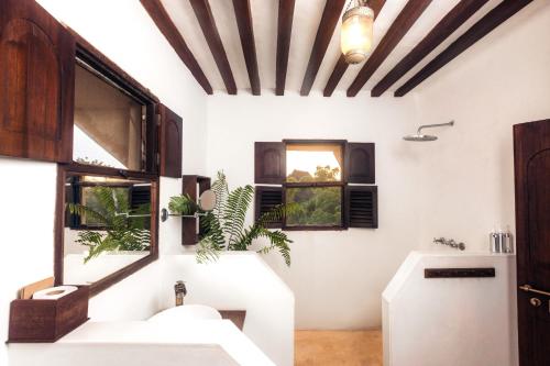 a bathroom with two sinks and two windows at Pepo Villa, Anasa Hotels & Experiences in Lamu