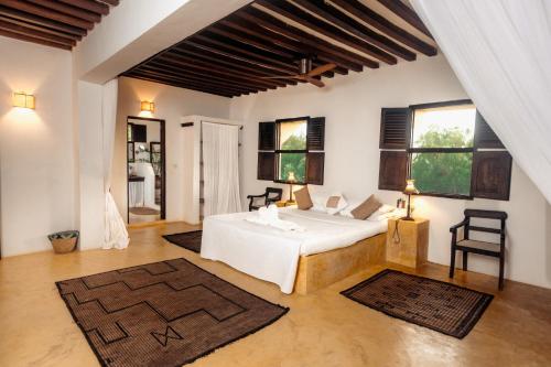 a bedroom with a white bed and two windows at Pepo Villa, Anasa Hotels & Experiences in Lamu