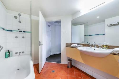 a bathroom with a sink and a shower at Two Adjacent King Suites with a Breezy Balcony in Darwin