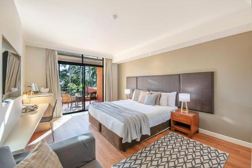 a bedroom with a large bed and a balcony at Two Adjacent King Suites with a Breezy Balcony in Darwin