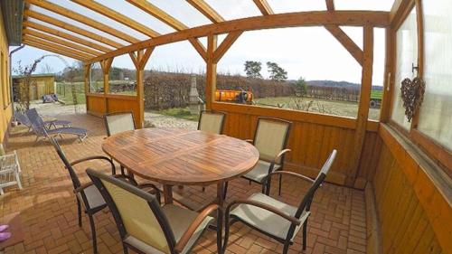 a wooden table and chairs on a patio at Ferienbauernhof - Ferienwohnung 6 in Grünow