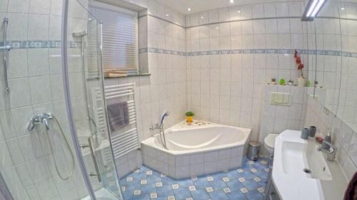 a bathroom with a tub and a shower and a toilet at Ferienbauernhof - Ferienwohnung 6 in Grünow