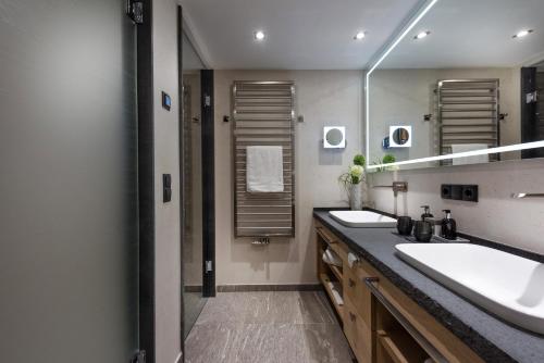 a bathroom with two sinks and a large mirror at Platzlhof - Mein Hotel im Zillertal in Ried im Zillertal