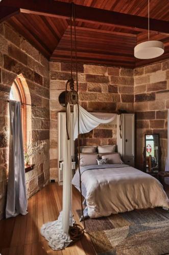 a bedroom with a bed in a brick wall at St Martins of Tasmania - converted heritage listed church in Dunalley
