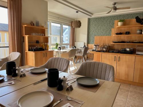 ein Esszimmer mit einem Tisch und einer Küche in der Unterkunft Haus Renée in Podersdorf am See