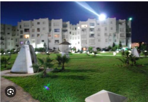 a large white building at night with a park at Résidence in Hammamet