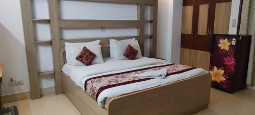 Friends Residency في نيودلهي: غرفة نوم بسرير ذو شراشف ووسائد بيضاء