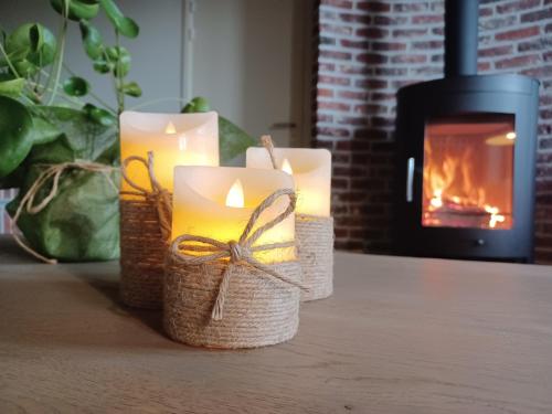 a group of candles on a table with a fireplace at Brabant17 in Poperinge