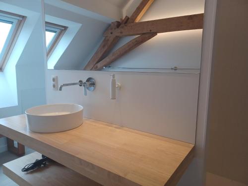 a bathroom with a sink on a wooden counter at Brabant17 in Poperinge