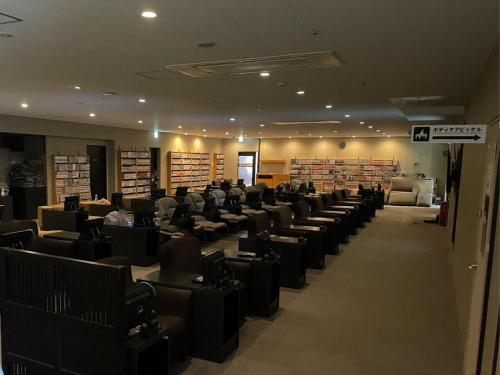 a room with rows of chairs in a library at The Centurion Sauna Rest & Stay Sapporo Male Only in Sapporo