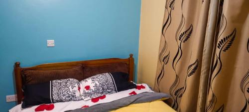 a bedroom with a bed with a blue wall at 2 Bedroom at Kamakis near Greenspot Long term 5 days plus in Ruiru