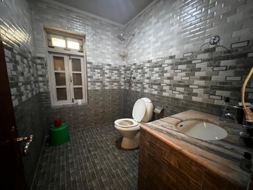 a bathroom with a toilet and a sink and a window at Eco Resort in Dhulikhel